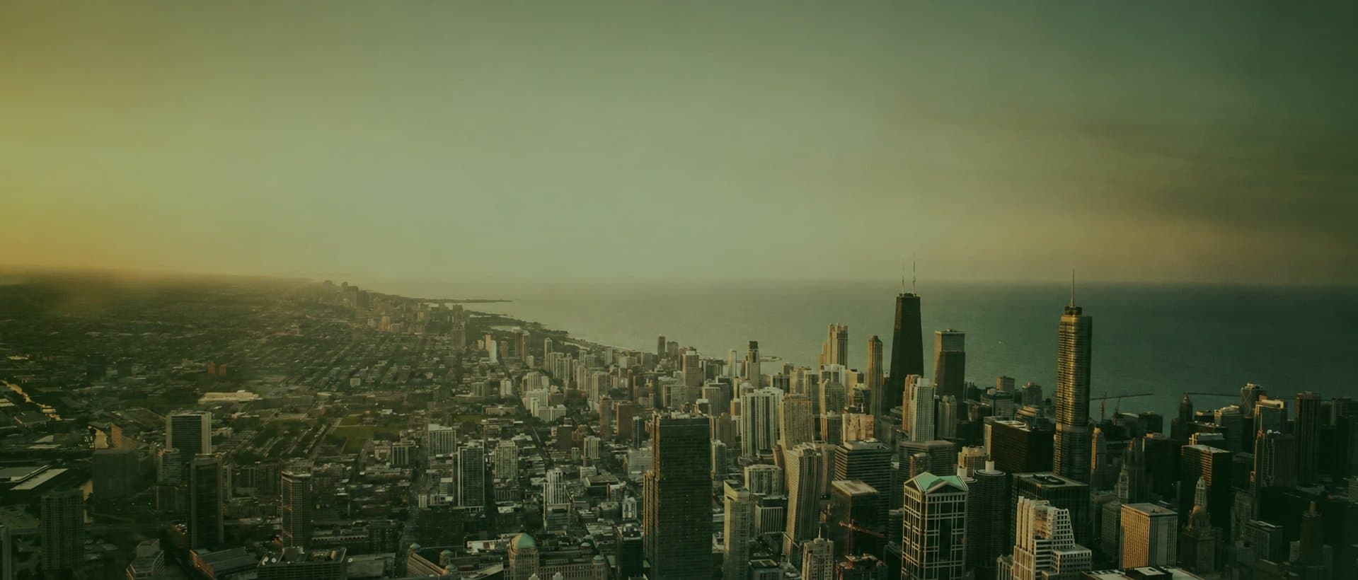 Aerial view of a city skyline along a lakeshore at dusk