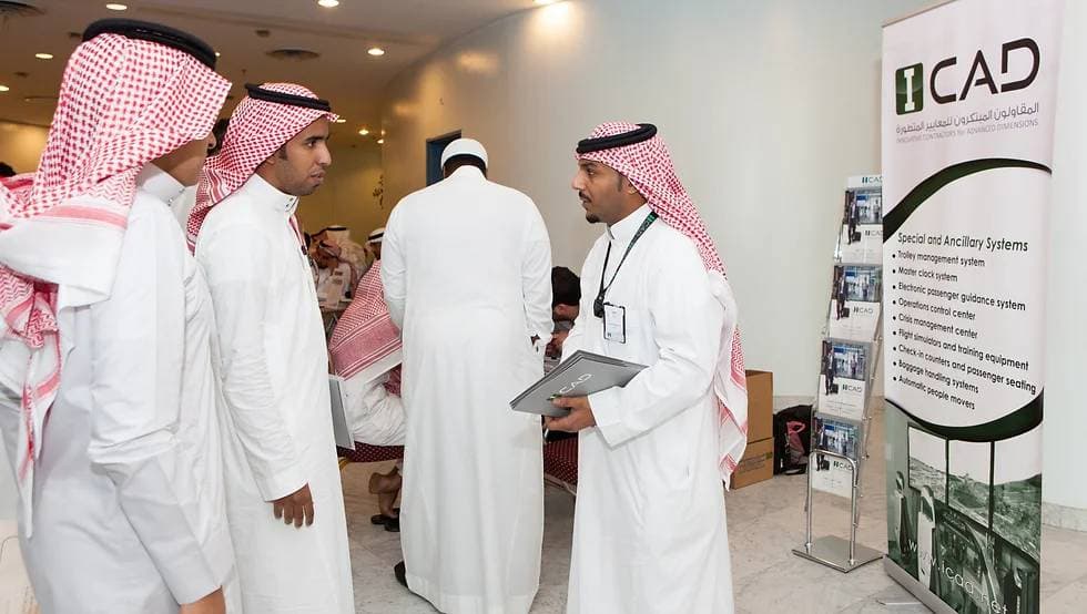 ICAD staff talking with candidates beside an ICAD stand at a recruitment fair
